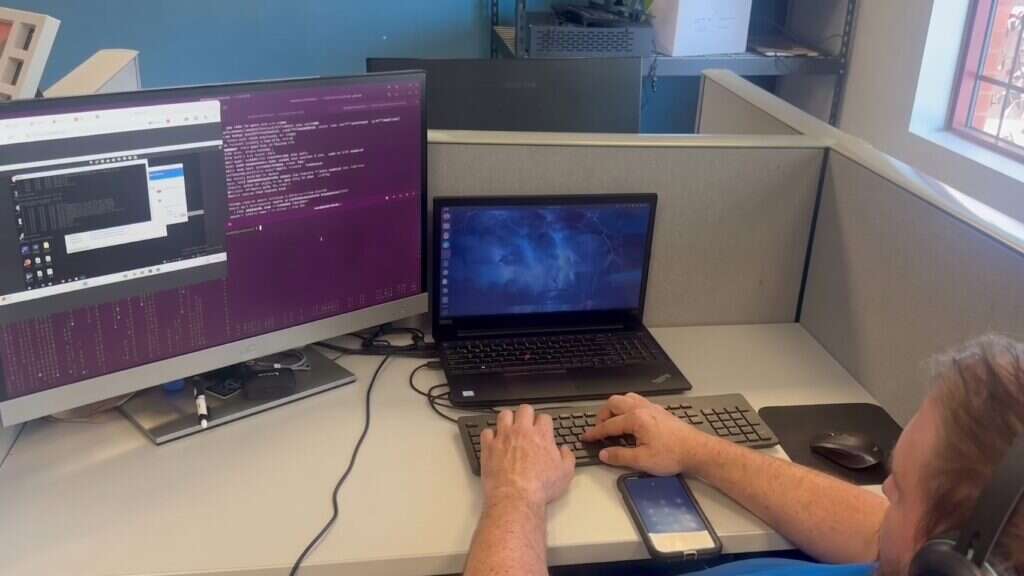 Buffalo IT Services engineer monitoring client systems across dual displays and a laptop