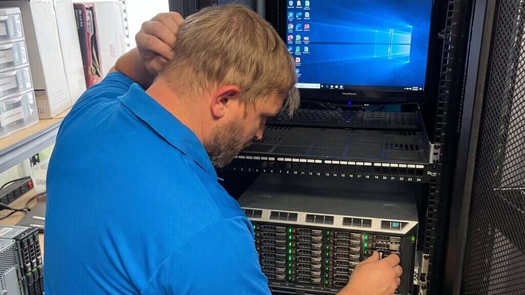 Buffalo IT Services technician servicing a rack-mounted server and patch panel