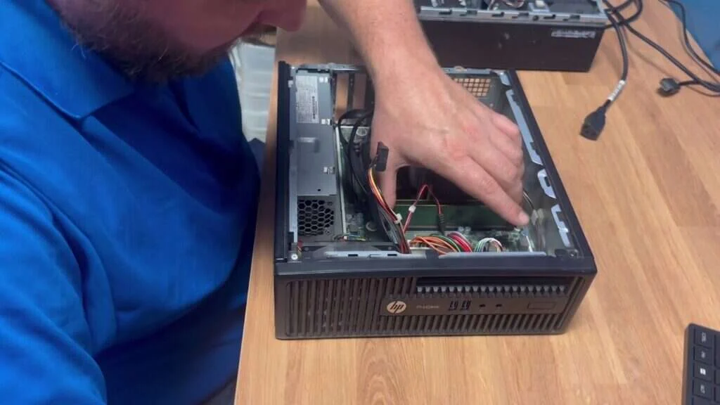 Buffalo IT Services technician performing hardware repair inside an HP ProDesk desktop