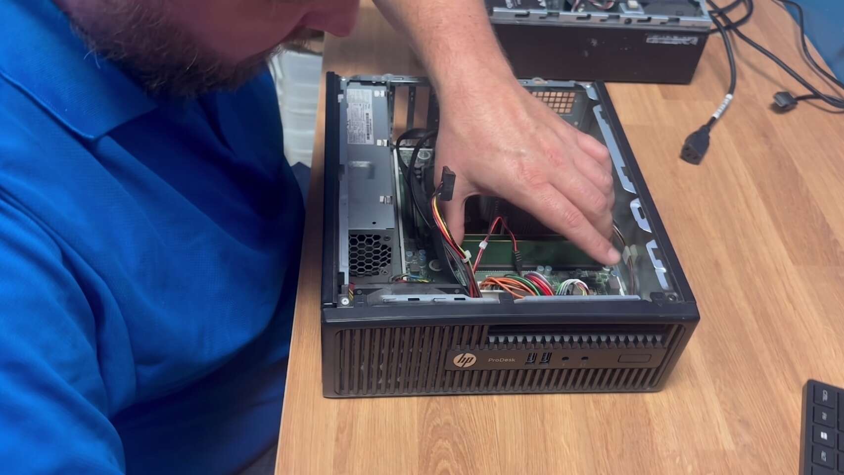 Buffalo IT Services technician repairing an HP desktop in the workshop